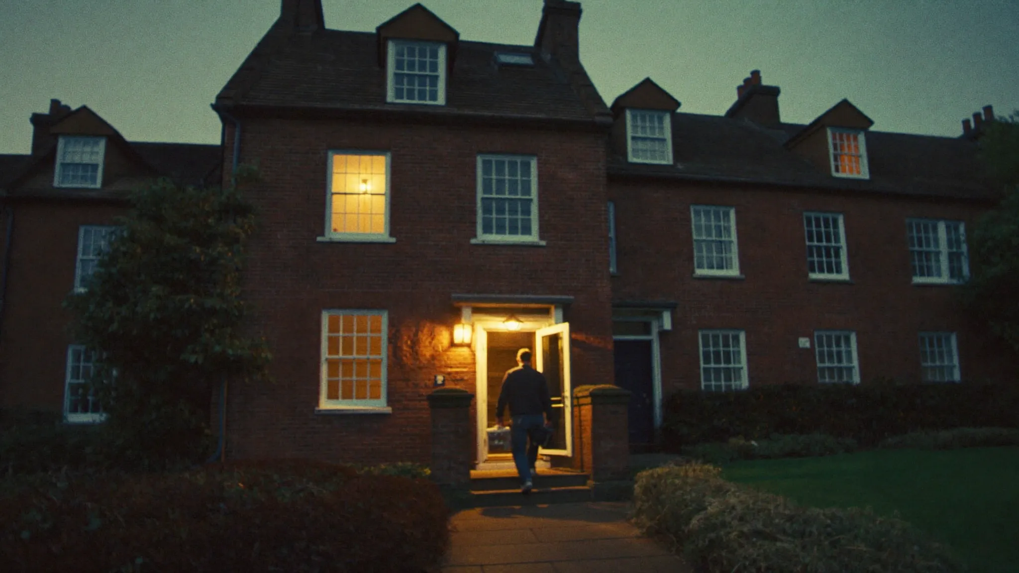A plumber arriving at a Dublin doorstep at dusk with his toolbag